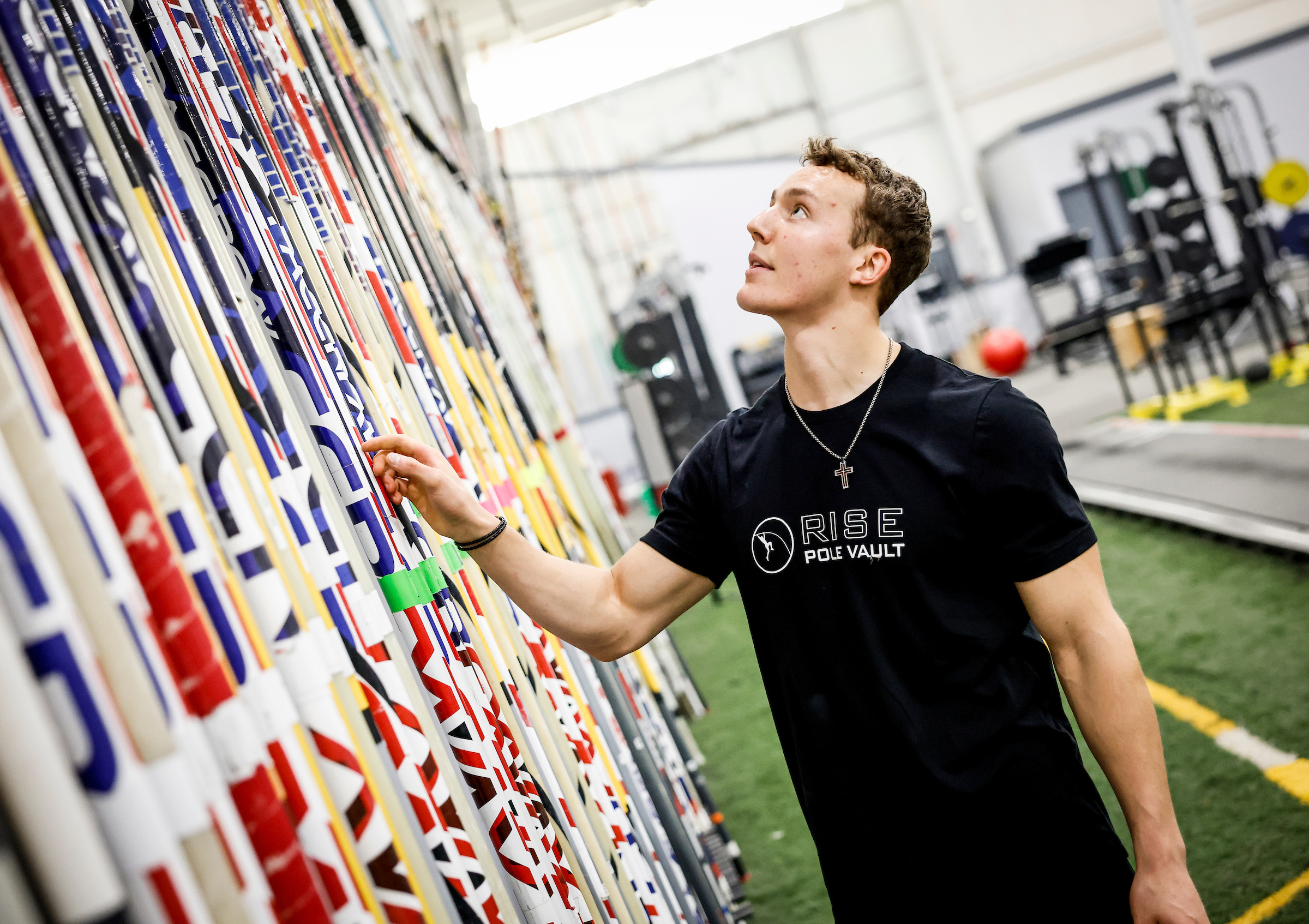 RISE Pole Vault athlete picking a pole from the rental rack